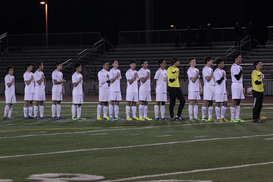 The varsity boys soccer team lines up for the National Anthem before the Vandegrift game.