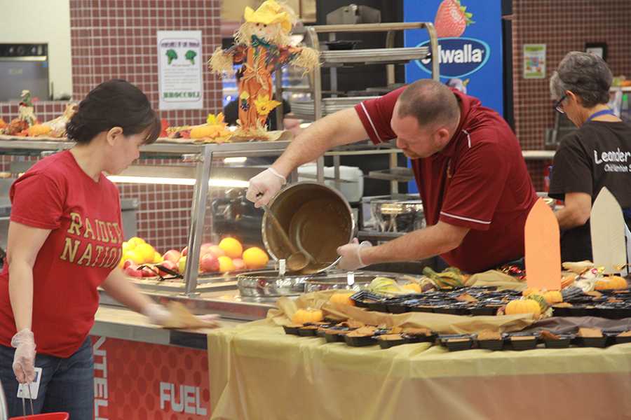 Principal John Graham adds more gravy to the Thanksgiving lunch line.