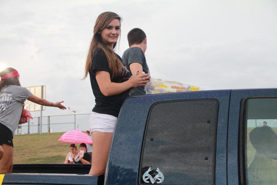 Junior Reagan Hjort rides on the FCA float during the Homecoming parade.