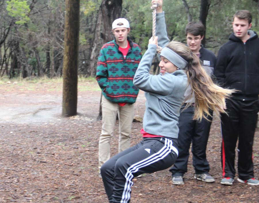 Senior Ara Matos swings, aiming to help her team in the low ropes course.