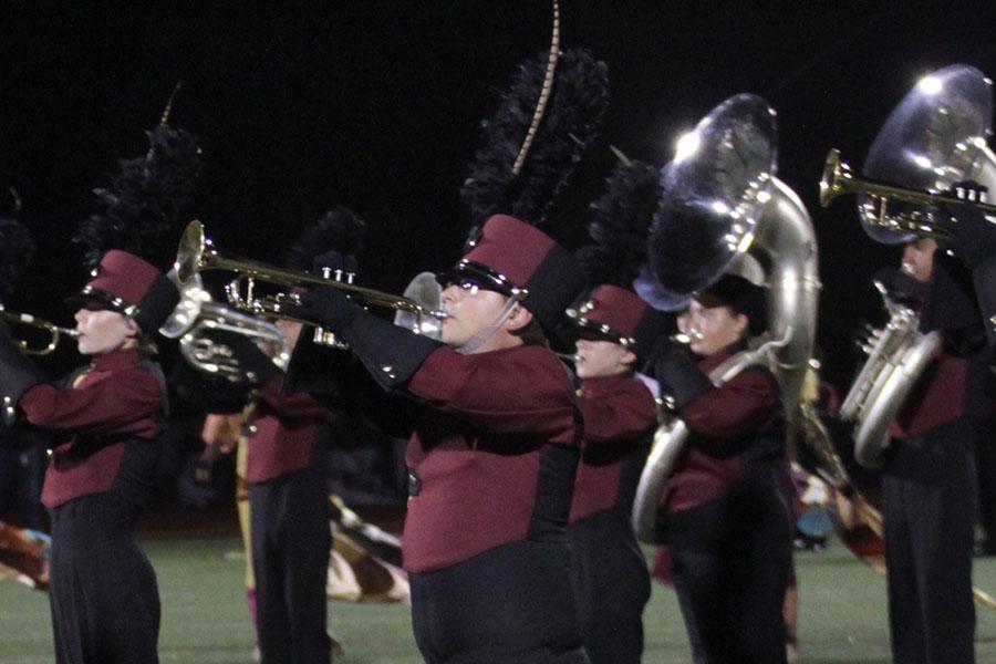Junior Mason Davidson (center) plays with the marching band at the Round Rock varsity football game.