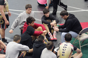 Coach Brad Bresnehen speaks with the team during the varsity district tournament.