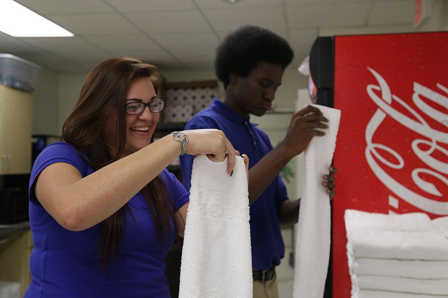 At Home 2 Suites, juniors Alyssa Hernandez and Alijia Poston fold towels. Hernandez and Poston are part of the Hospitality Services class that interns at hotels and local restaurants to learn more about the industry.