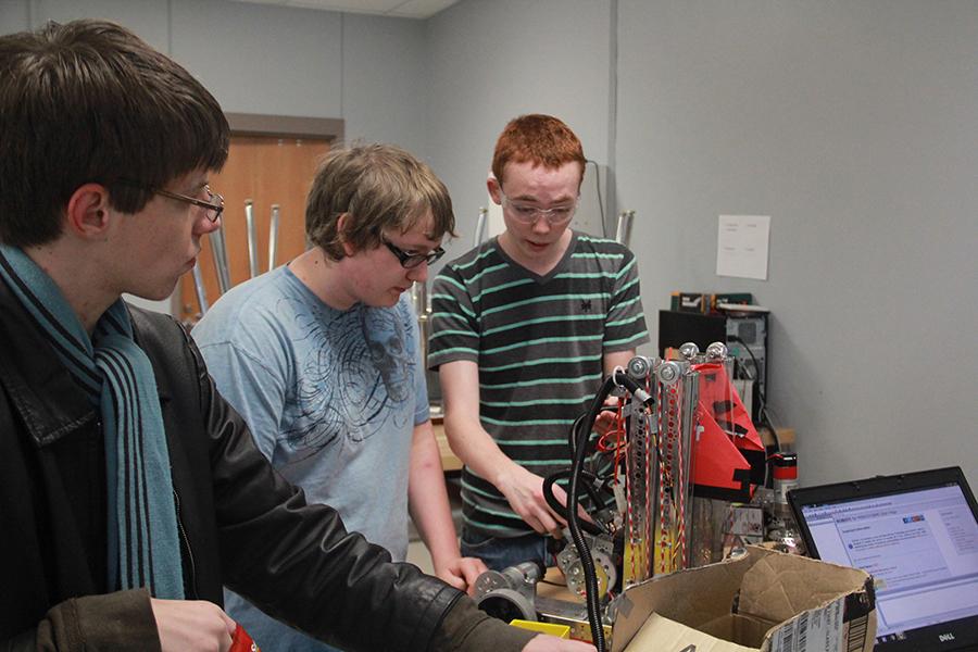 Sophomore Eli Mitchell, junior Brandon Berkel and sophomore Kelton Arms work together on a robotics project.