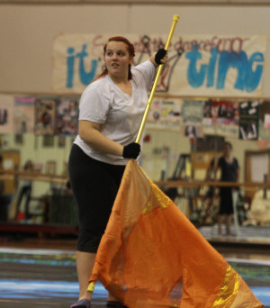 Senior Callie Dowdle spins flag during a practice run of this years indoor winter guard show