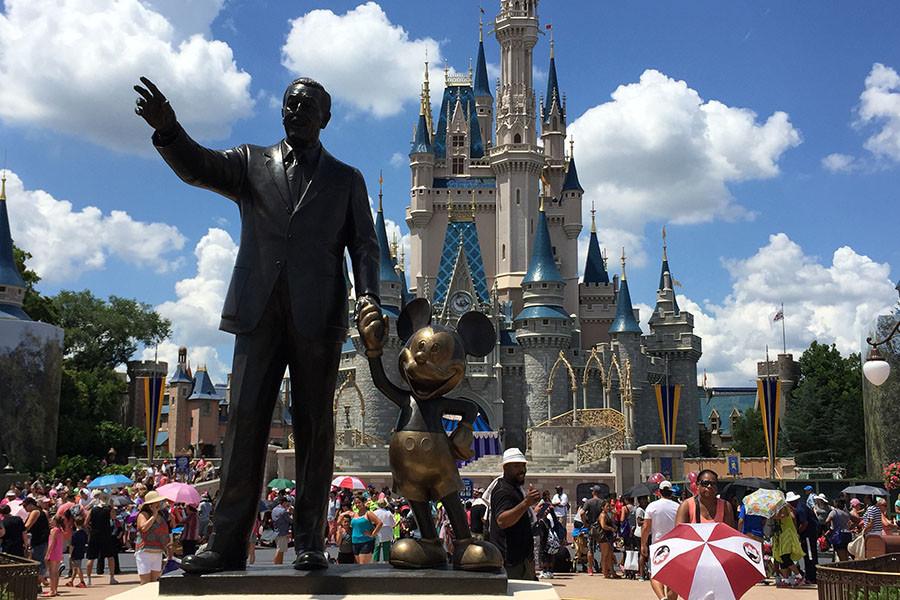 In front of Cinderellas castle is a statue of Walt Disney with Mickey Mouse.