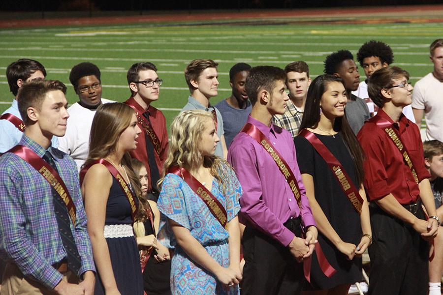 The Dukes and Duchesses stand on the track at the football stadium after being announced at the end of the Homecoming pep rally.