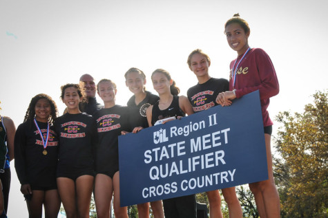 The varsity girls hold their state qualifier banner at the regional meet.
