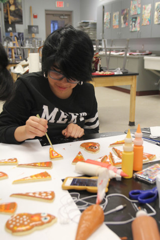 Abriel Morales decorates cookies during an Art Club meeting.