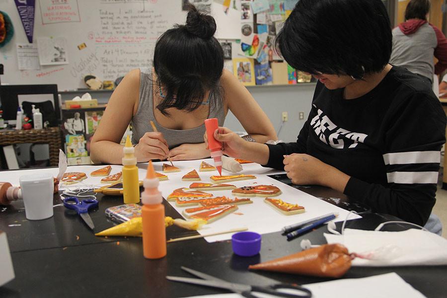 Esther Kim and Abriel Morales decorate cookies during an Art Club meeting.