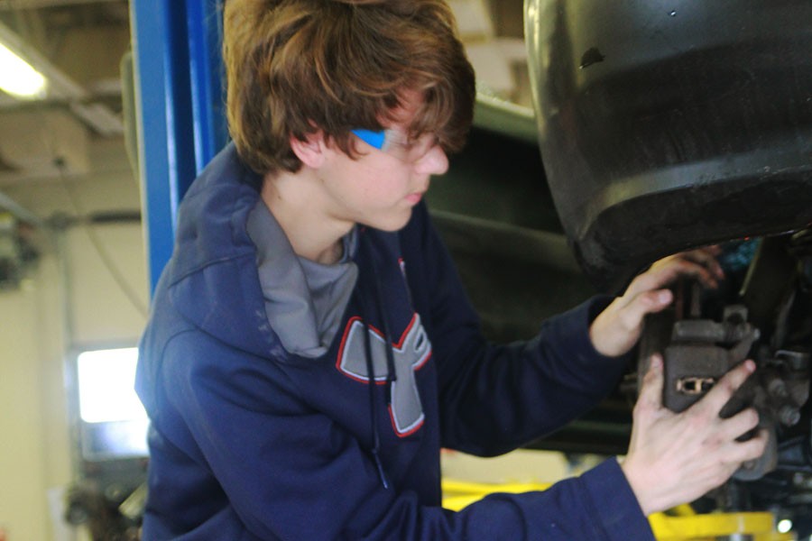 Senior Wesley Blake changes a tire in Auto Tech.