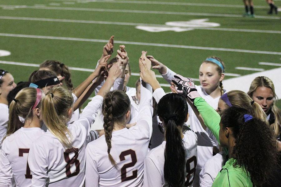 Gathering together, the varsity girls raise their hands together in the R symbol before the Cedar Ridge match. The school symbol was part of the team’s pre-game rituals which also included warming up to game day music like “Fergalicious,” “Jump Man” and “Lip Gloss.”
