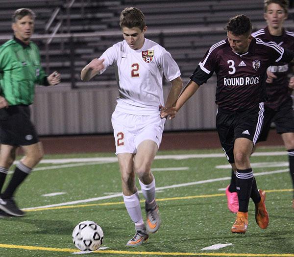 Watching the ball, junior Travis Long plays in the home district match against Round Rock. Long, who played left wing, was on the varsity team for his third year. “We are one big family,” Long said. “We work hard till the last second, and we never give up, win or lose.” 
