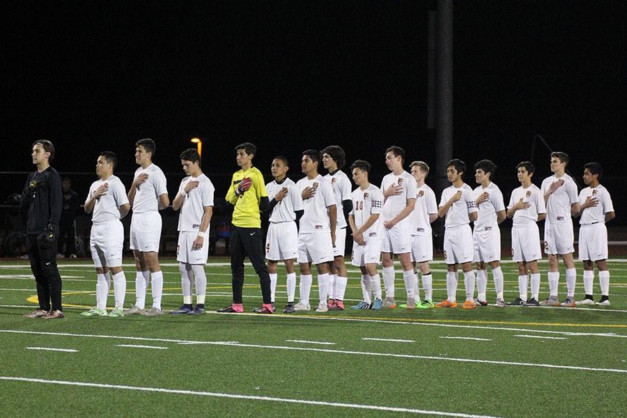 Before the Cedar Ridge match, the varsity team lines up on the field for the national anthem. The Raiders won the home match during the first round of district, 2-1. “We believed we could win and we worked hard as a team to take down Cedar Ridge,” sophomore Cohen Reed-Green said (seventh from the right).
