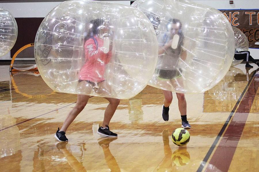 Sophomore Taylor Douthitt and freshman Maxine Matl clash against each other during the first game of the bubble soccer tournament.
