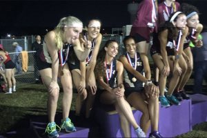 The girls 4x400 relay team receive their medals on the podium.