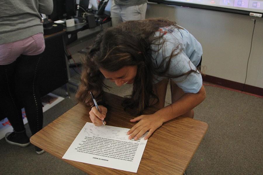 Sophomore Erika Zaragoza signs the Resolution of Respect, April 4.