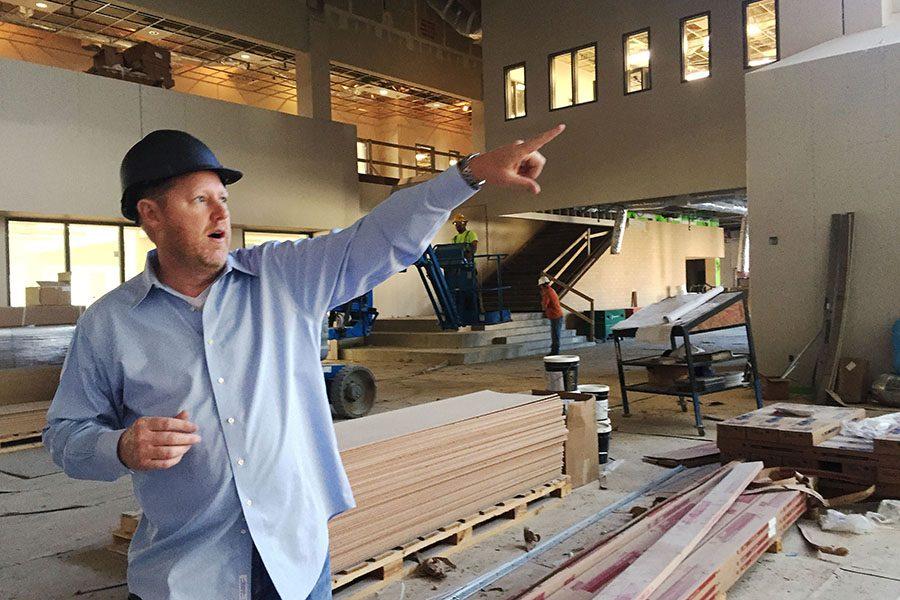 Project construction manager James Conkle points a second floor feature in the Commons area of campus.