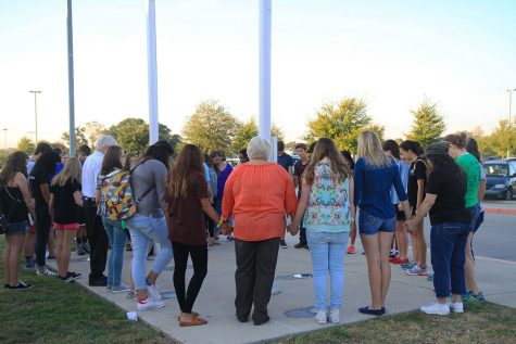 Students and teachers gather around the flag pole to pray at the annual See You at the Pole.