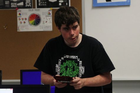 Zach Gagnon plays a game on a individual console during Video Game Club.