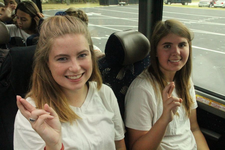 Seniors Krystal Almond and Sarah Jecker hold up their Rs on the bus to State.