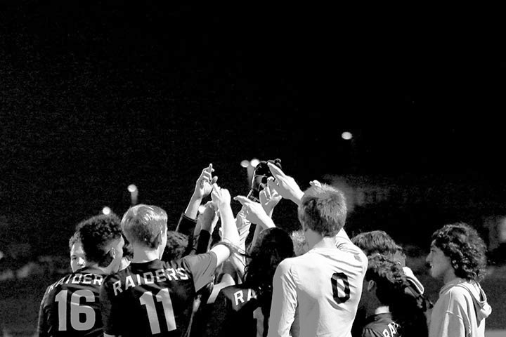 ALIVE AND KICKIN 
Before they take the field against Glenn HS Feb. 5, varsity boys soccer players huddle together and flash their Rs to show team pride. 