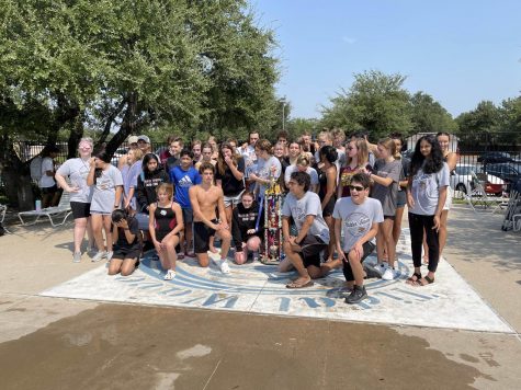The swim team poses with their trophy after winnning their first meet against Glenn and Leander.