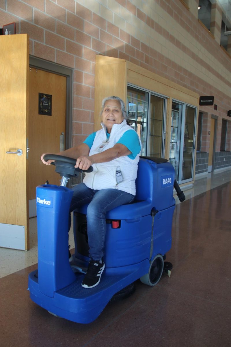Custodian Estela Herrera drives a floor polisher. Herrera has worked here since the opening of the school, for a total of 16 years.