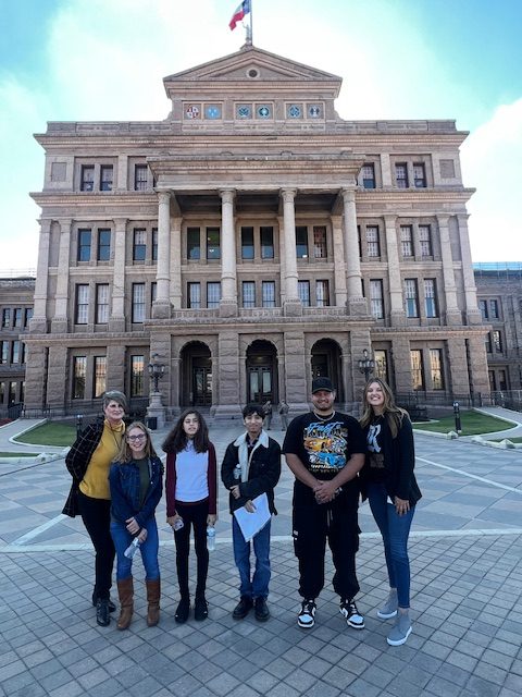 Isaac+Pedroza+stands+in+front+of+the+Austin+Capitol+with+his+teachers+and+student+peers.