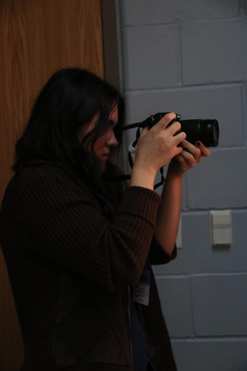 Junior Stella Mcpherson takes pictures of theater in the dressing room.