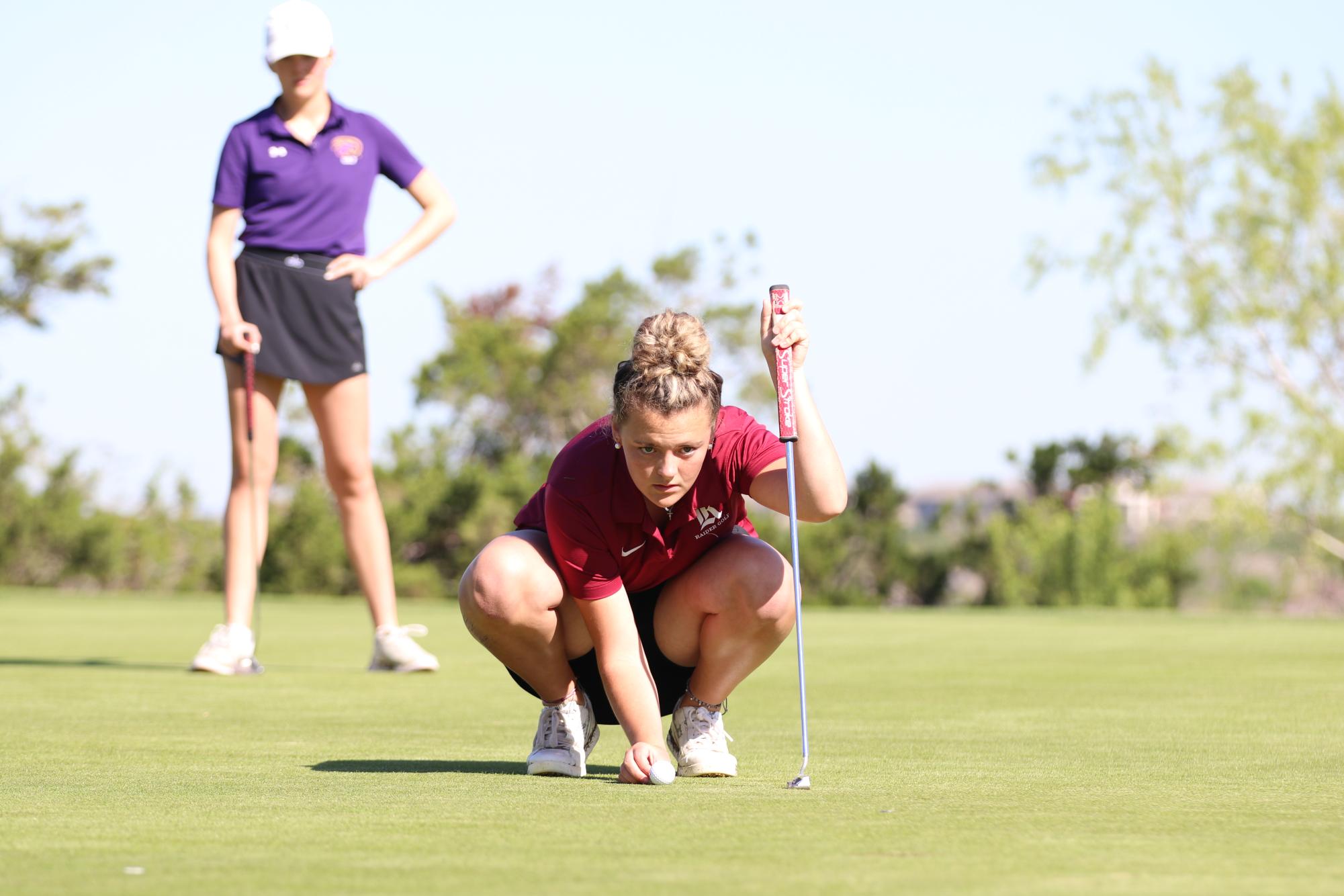 As she sets the ball on the green, junior Ava Wallace studies the course. Following district, Wallace practiced three times a week at the Crystal Falls Golf Course. “Going into district, I knew I had to have a really strong mentality because golf is a mental sport,” Wallace said. “I took time to myself and just focused on my mental and keeping it strong no matter what happens I try to stay level headed.” 
