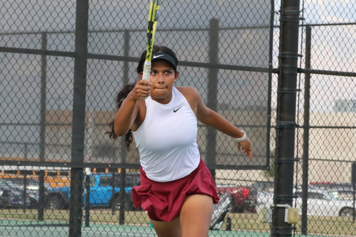 During the singles match, senior Shivani Sreekanth pauses, turns and aims the ball towards her opponent. 
