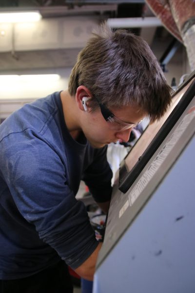 Air & Fuels: Tuned in with zero distractions, junior Liam Earley uses a blasting cabinet. He took Auto Tech I as a possible career path. “I am planning on trying to have a career or a future planned with automotive,” Earley said. “I’ve always enjoyed working with cars because it’s just big legos in a way.
